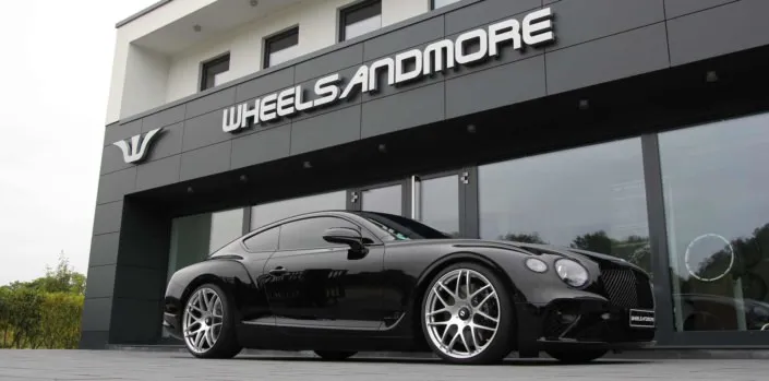 tuning-new-continental black bentley in front of wheelsandmore